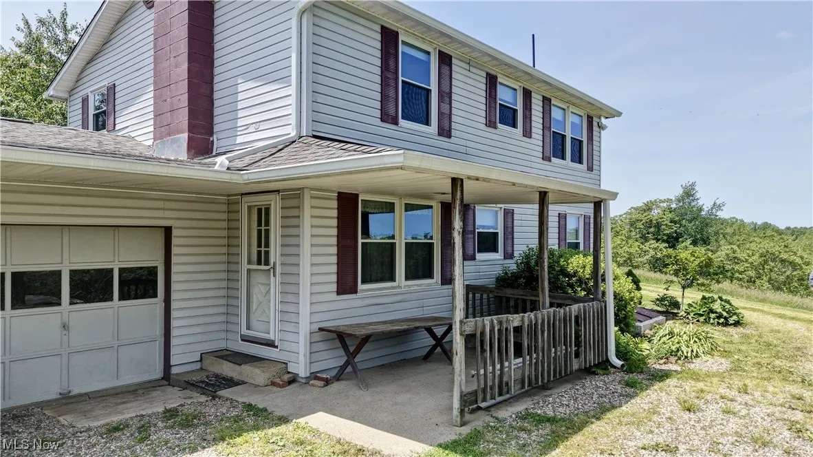 View of front of house featuring covered porch and a shingled roof