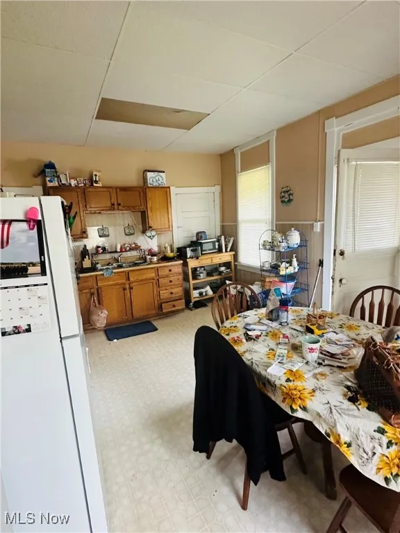 Dining room featuring light floors and a paneled ceiling