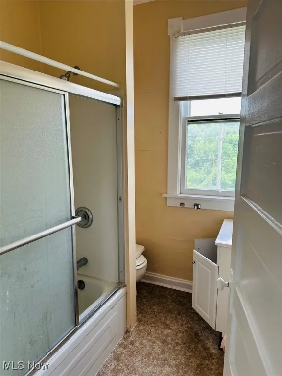 Bathroom featuring vanity and shower / bath combination with glass door