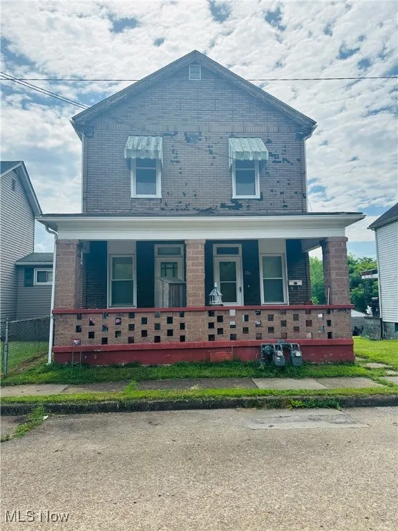 View of front of property with brick siding and covered porch