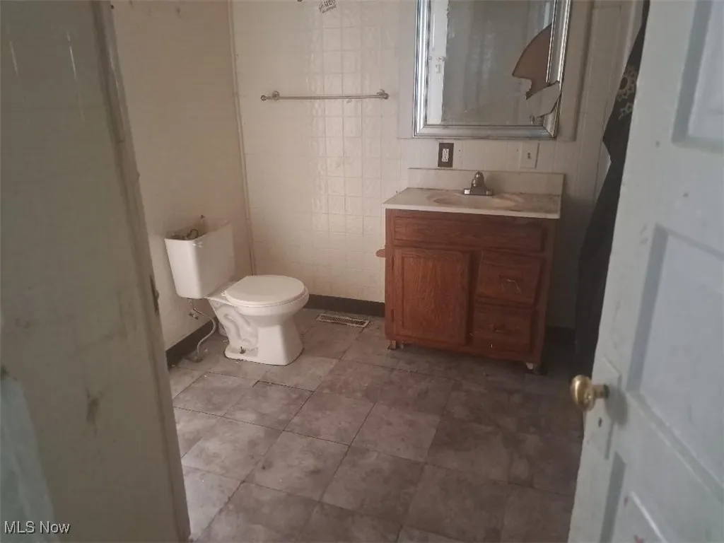 Bathroom featuring vanity and tile walls