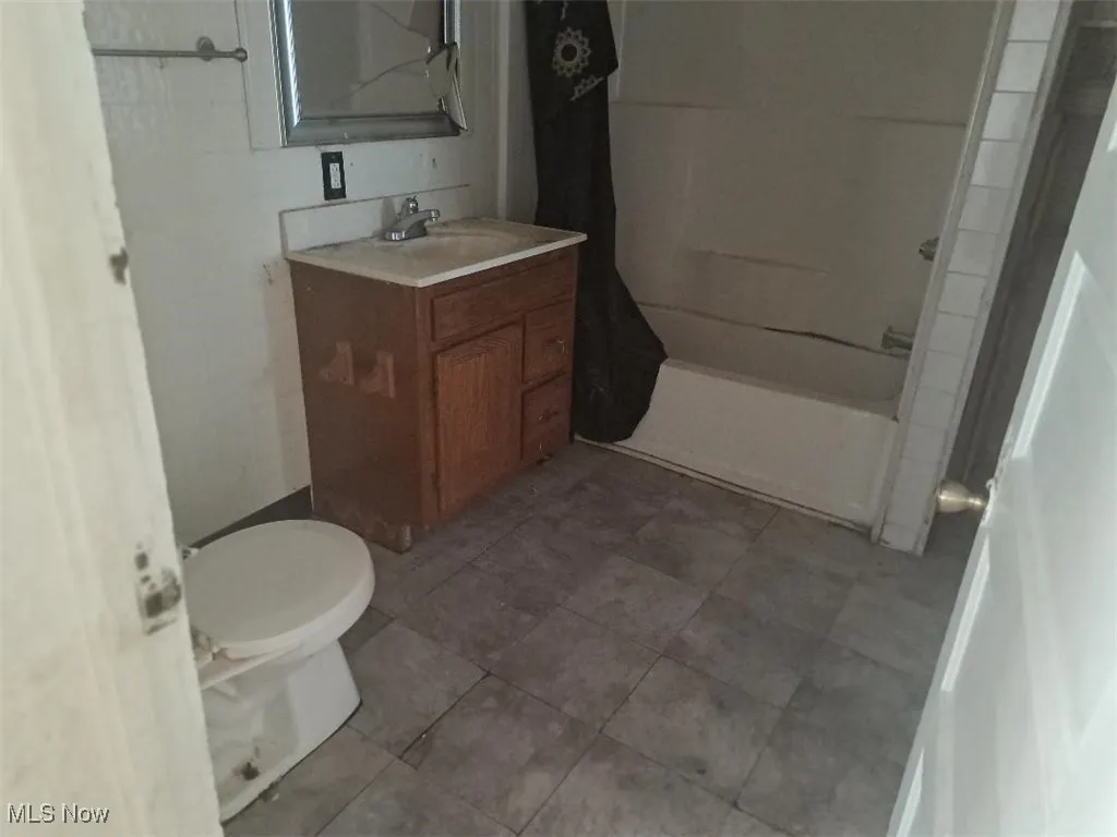 Full bath with vanity, washtub / shower combination, and tile patterned floors