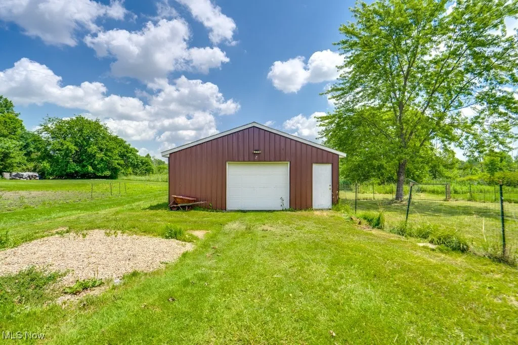 View of outbuilding with driveway and a view of rural / pastoral area