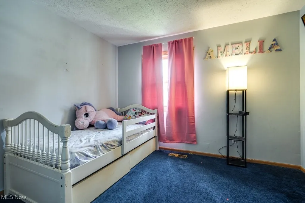 Bedroom with carpet flooring and a textured ceiling