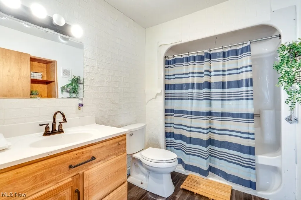 Full bath featuring vanity, wood finished floors, and a shower with shower curtain