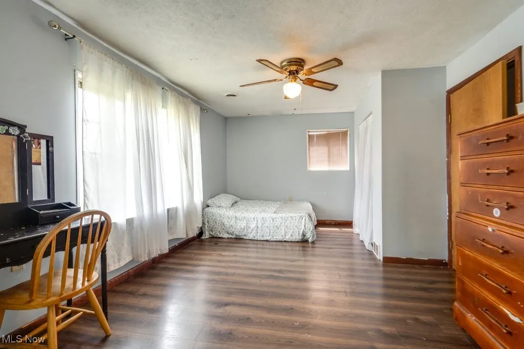 Bedroom with dark wood-style flooring and a ceiling fan