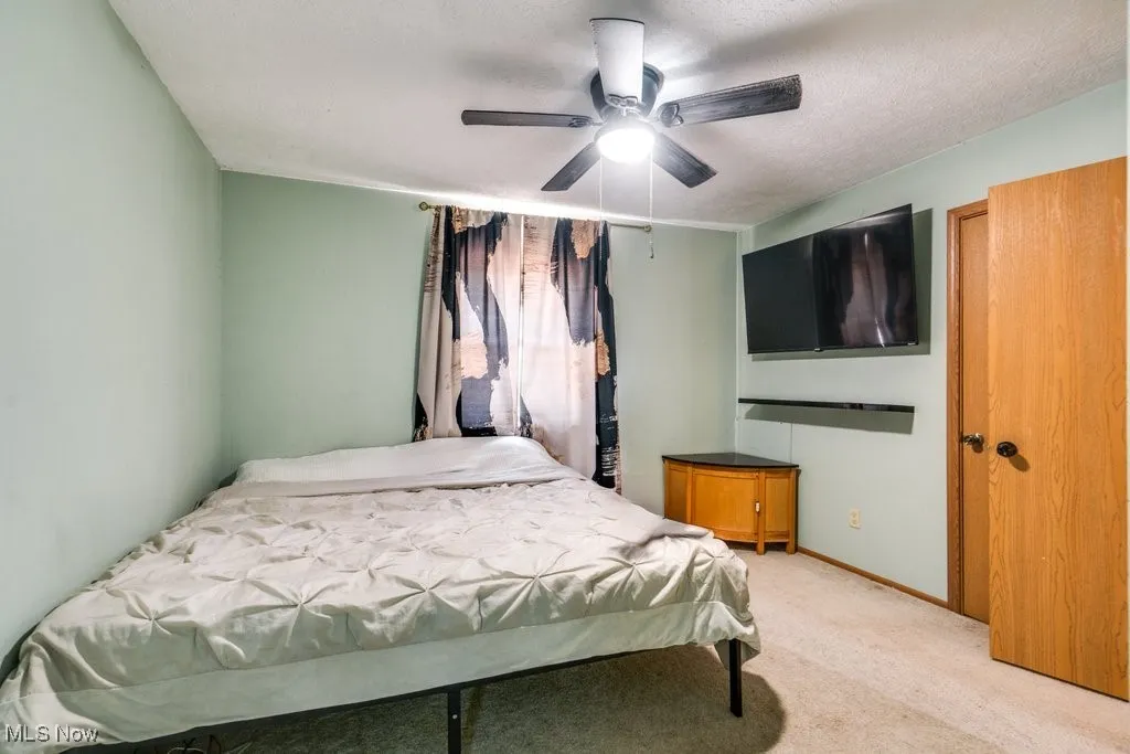 Bedroom featuring light colored carpet and ceiling fan