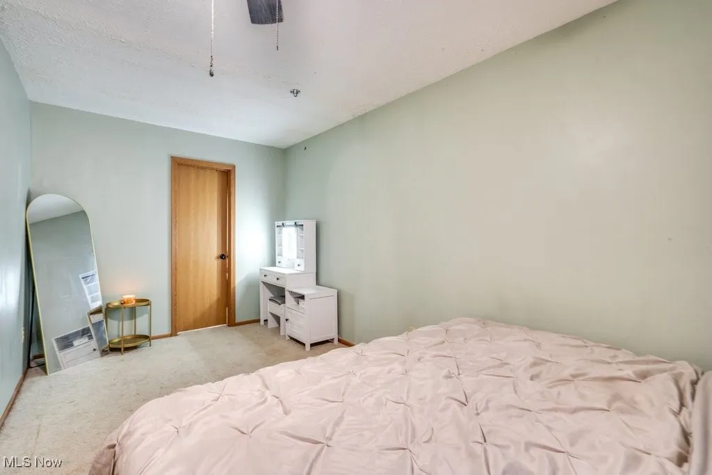 Bedroom featuring light carpet and a ceiling fan