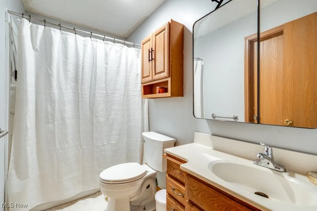 Full bath with vanity and a shower with curtain