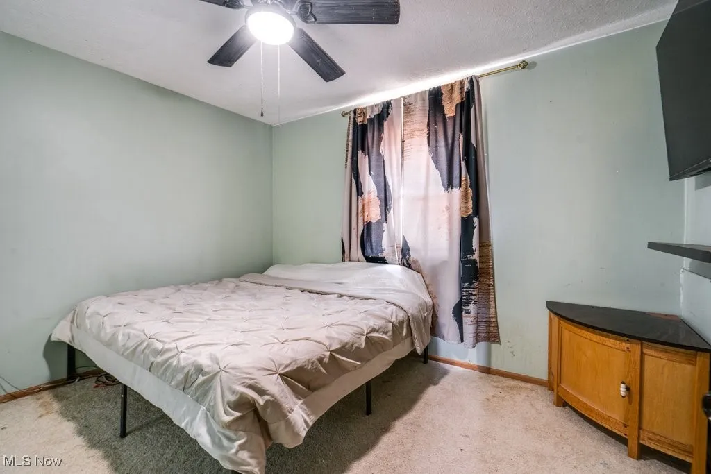 Bedroom featuring light colored carpet and ceiling fan