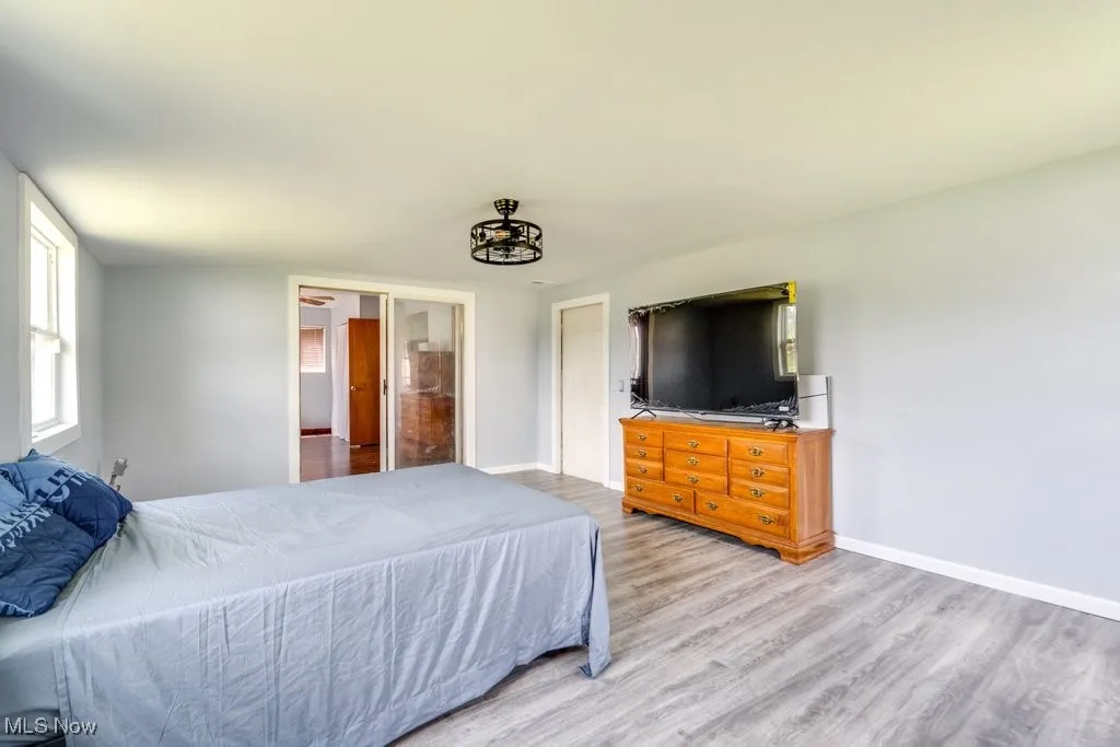 Bedroom with wood finished floors and baseboards