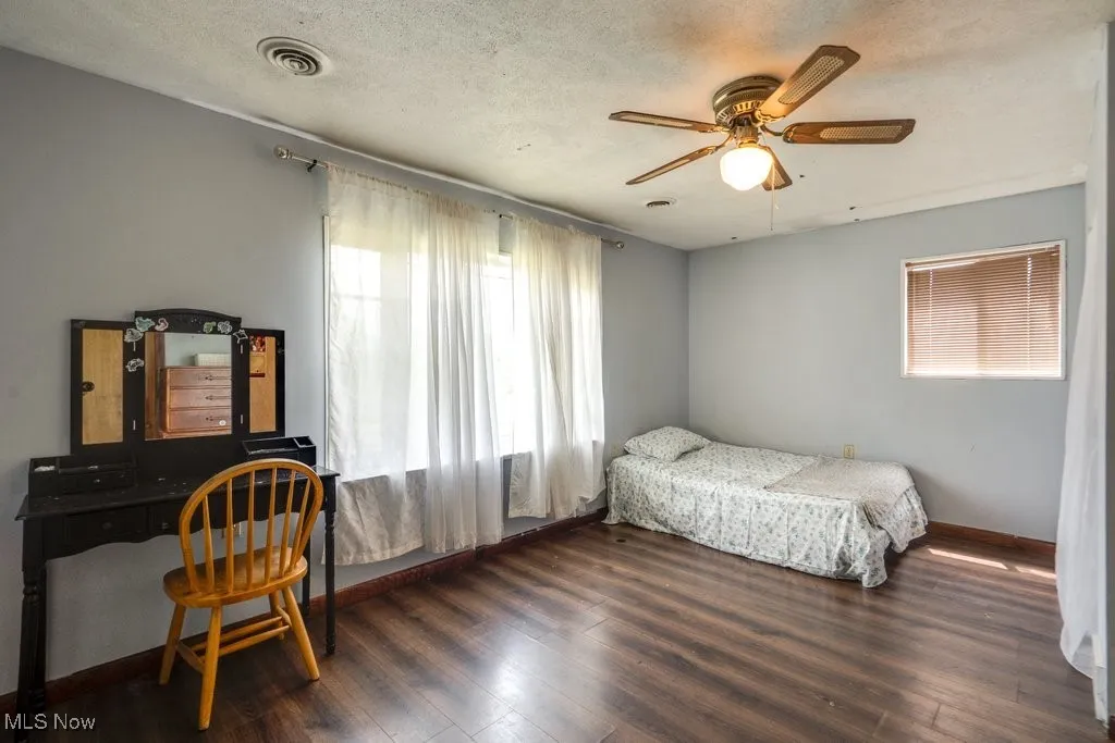 Bedroom featuring wood finished floors, a ceiling fan, and a desk