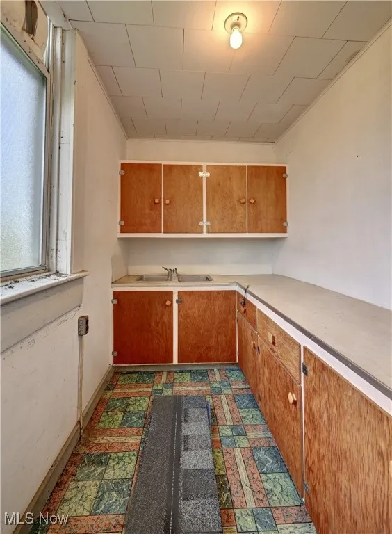 Kitchen featuring light countertops and brown cabinets
