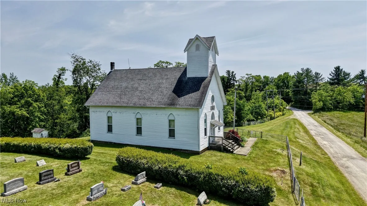 View of side of property featuring a shingled roof