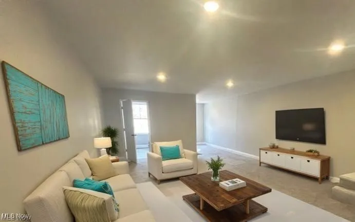 Carpeted living area with recessed lighting and baseboards