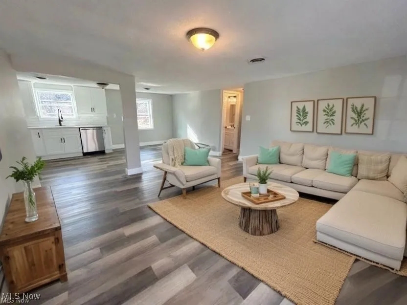 Living room featuring dark wood-style floors and baseboards