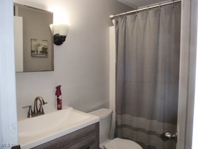Full bath featuring vanity and curtained shower