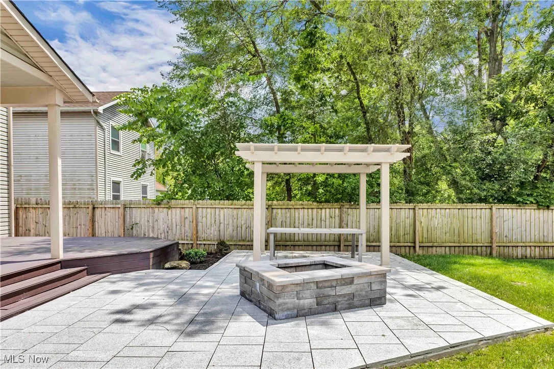 Fenced backyard with a covered deck, patio area with firepit and pergola