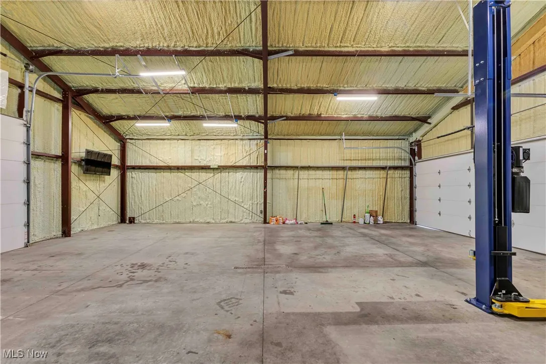 Outbuilding with concrete floor, overhead lighting, electric available, drain and furnace.