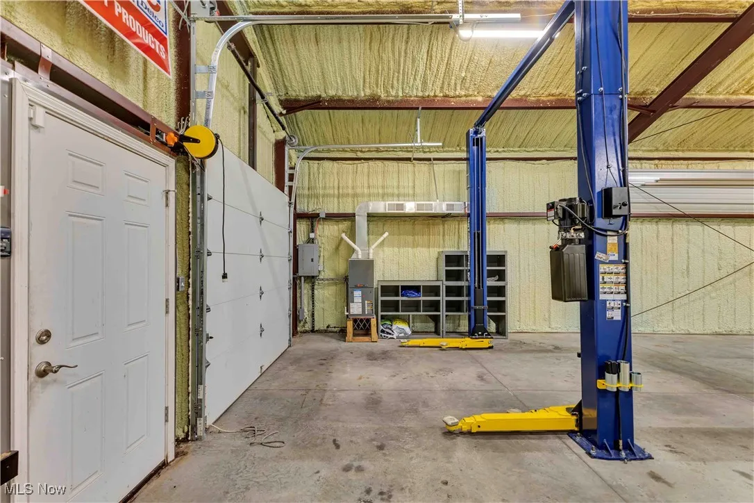 Outbuilding has 2 doors and man door at the front, furnace, overhead lighting, electric available and drain.