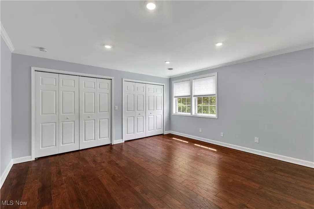 2nd floor bedroom featuring crown molding, two closets, wood-type flooring, and recessed lighting