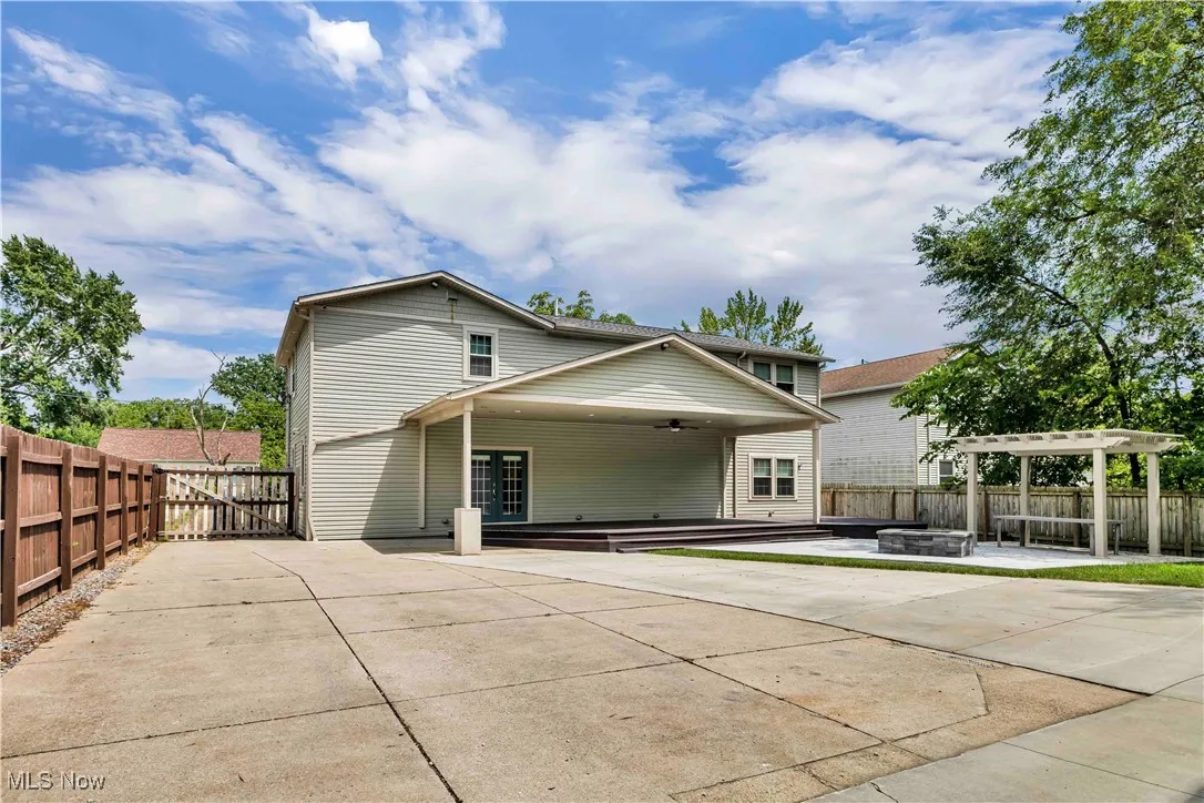 Back of property with a covered patio, a fire pit, a pergola, and a fenced backyard