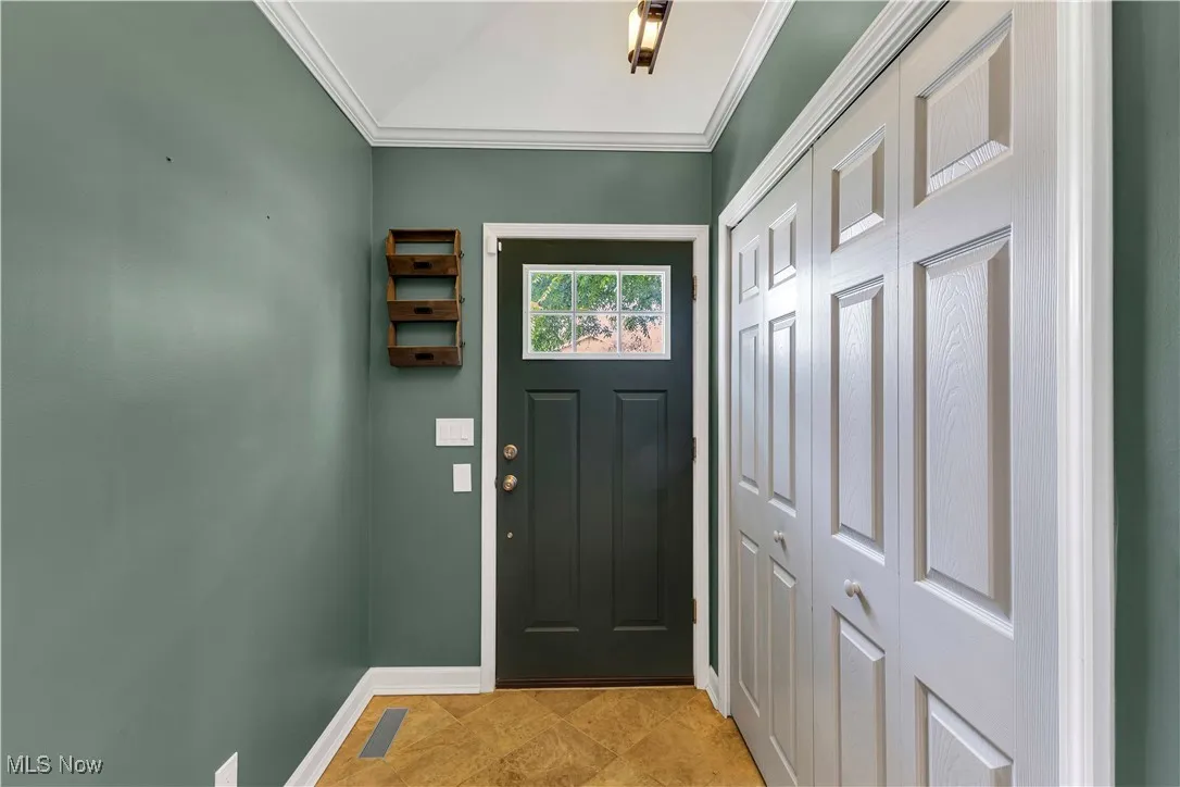 Entryway with crown molding and large coat closet