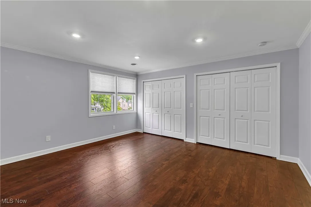2nd floor bedroom featuring crown molding, two closets, wood-type flooring, and recessed lighting