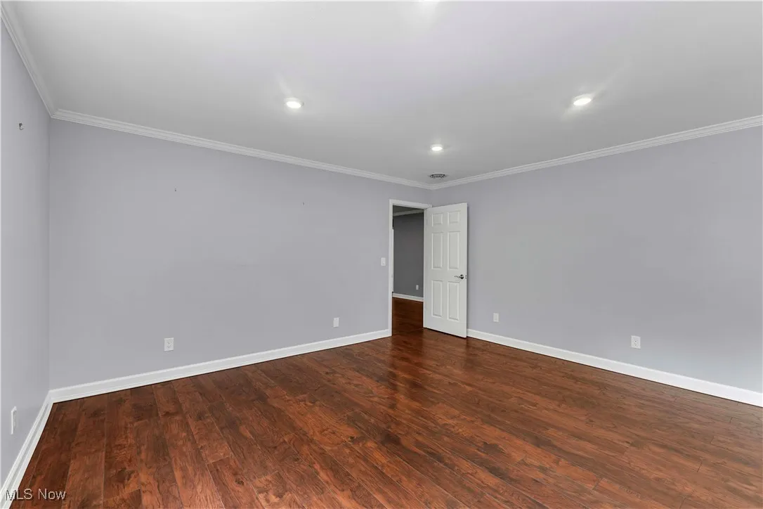 2nd floor bedroom featuring crown molding, two closets, wood-type flooring, and recessed lighting