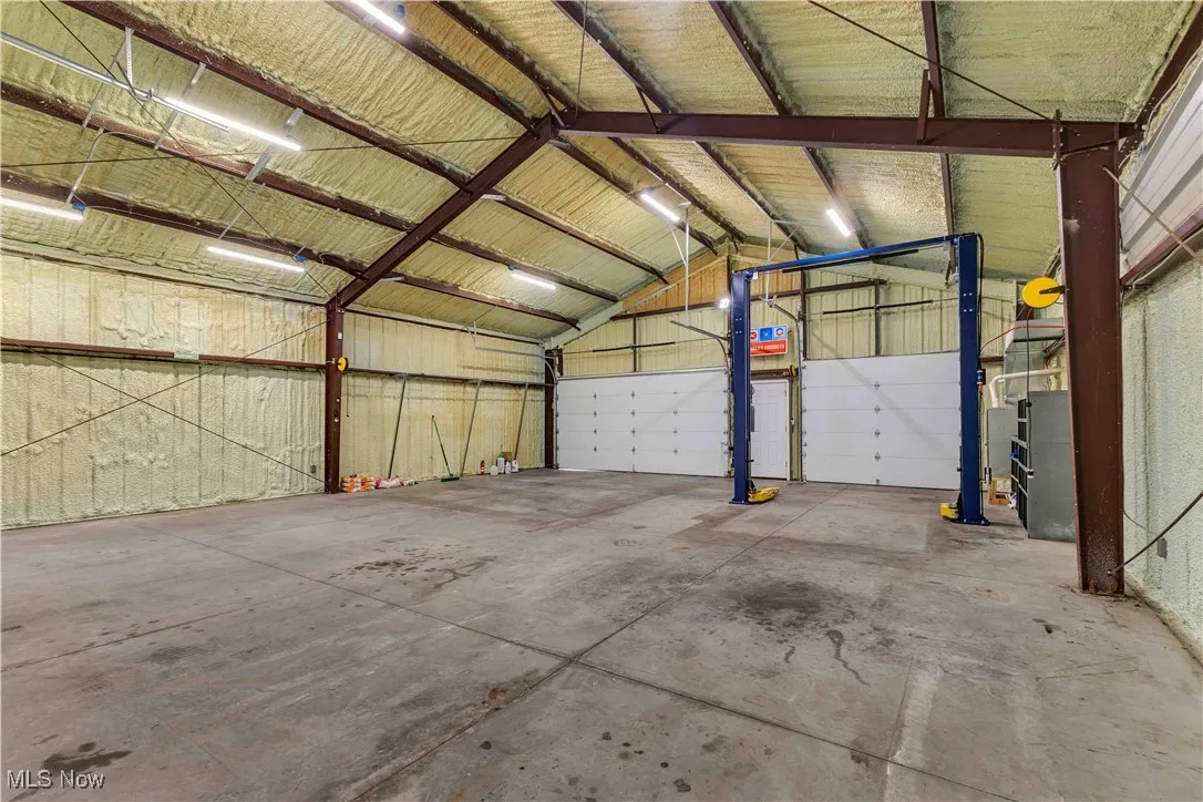 Outbuilding has 2 doors and man door at the front, furnace, overhead lighting, electric available and drain.