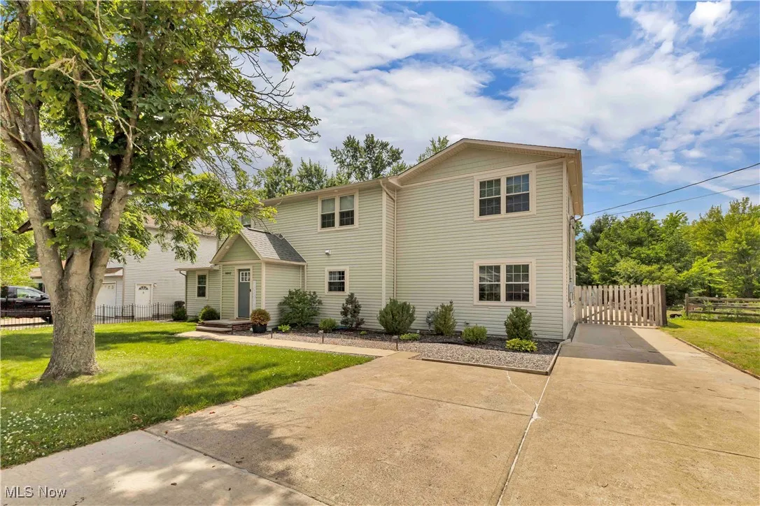 Traditional colonial - 2 story home with wide driveway and private wooden gate to enclose the backyard.
