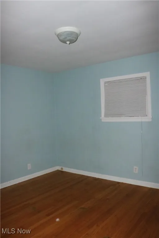 Empty room featuring dark wood-style flooring