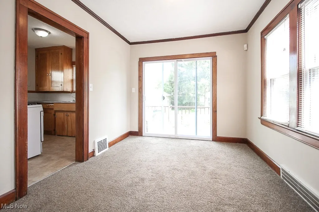Spare room with light carpet and crown molding