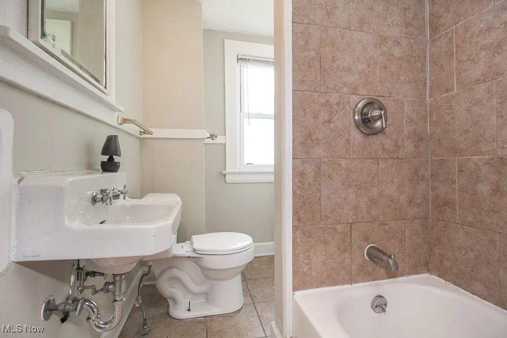 Bathroom with tile patterned flooring and bathtub / shower combination