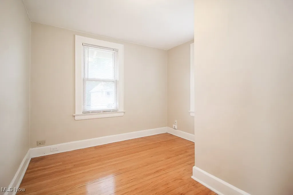 Spare room featuring light wood-style floors and baseboards