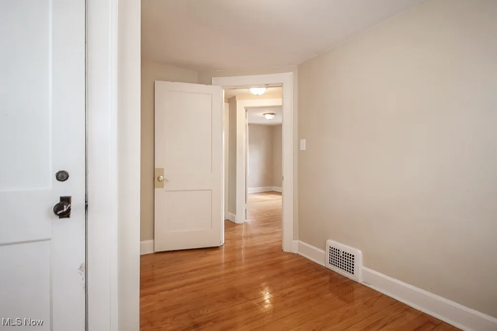 Corridor featuring light wood finished floors and baseboards