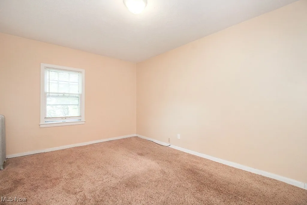 Empty room featuring carpet and baseboards