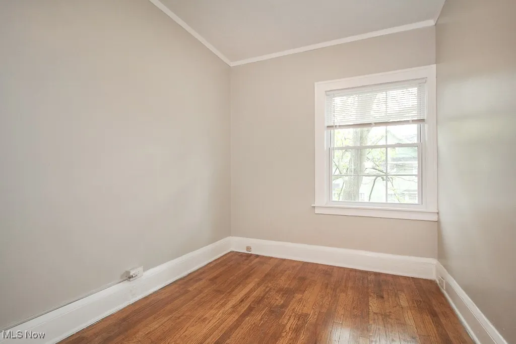 Unfurnished room featuring crown molding and hardwood / wood-style flooring