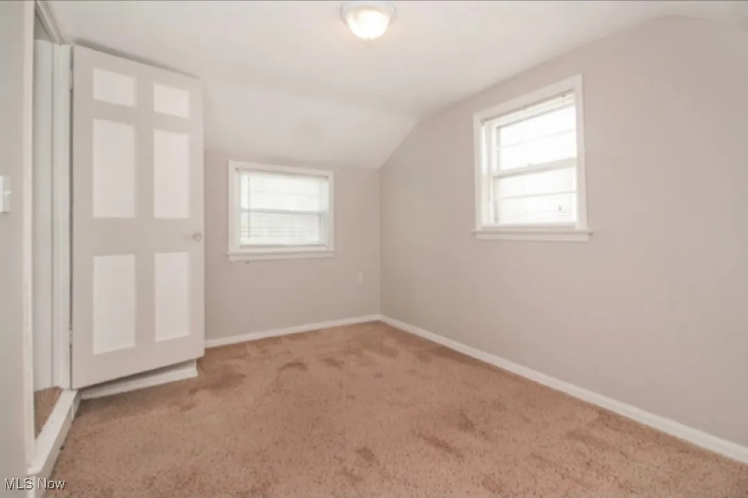 Additional living space with lofted ceiling and carpet floors