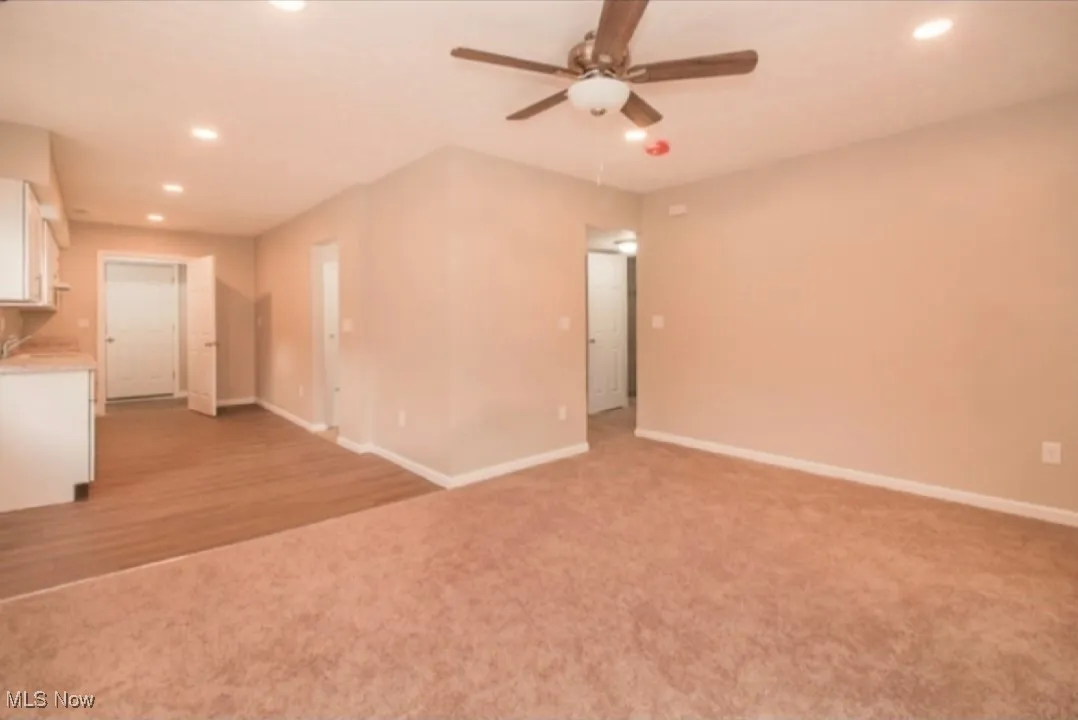 Unfurnished living room with recessed lighting, a ceiling fan, and light carpet