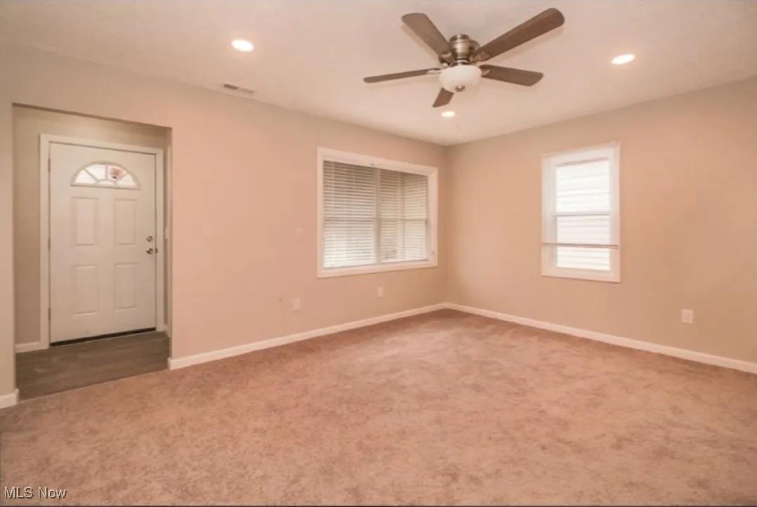 Carpeted empty room with ceiling fan and recessed lighting