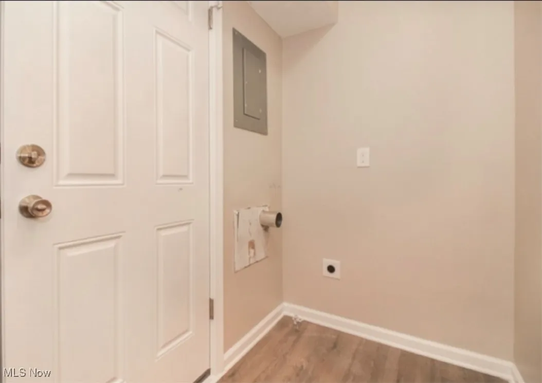 Laundry area featuring hookup for an electric dryer, wood finished floors, and electric panel