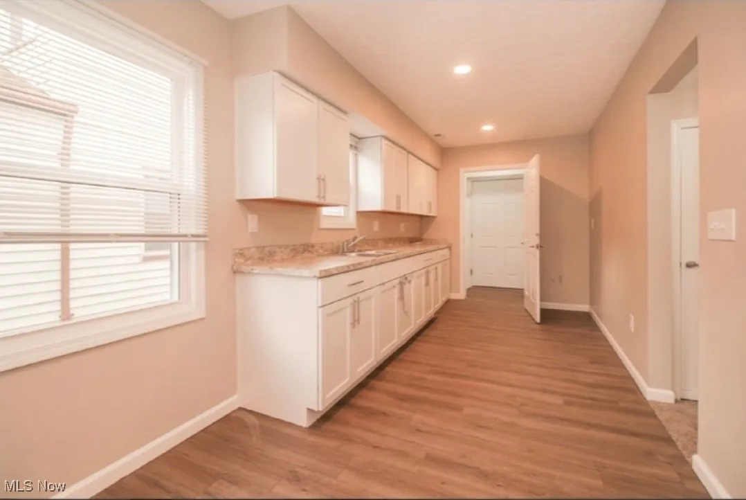 Kitchen featuring light countertops, white cabinets, recessed lighting, and light wood-type flooring