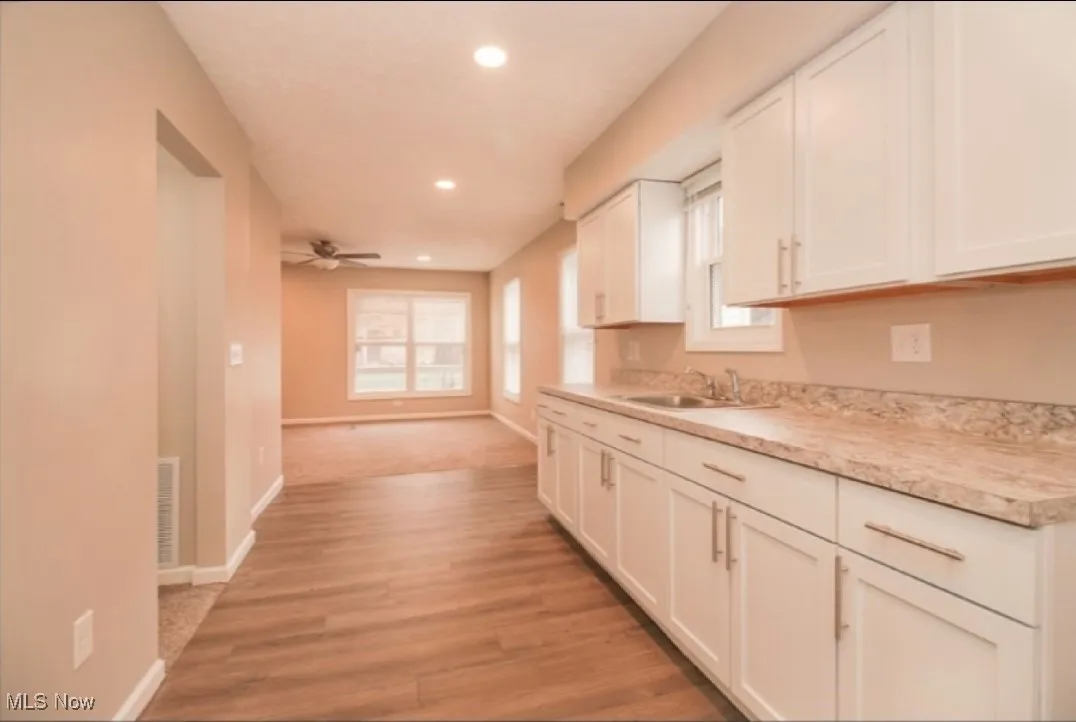 Kitchen featuring plenty of natural light, recessed lighting, white cabinetry, and light countertops