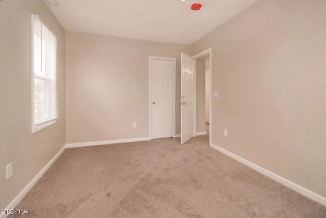 Empty room featuring light colored carpet