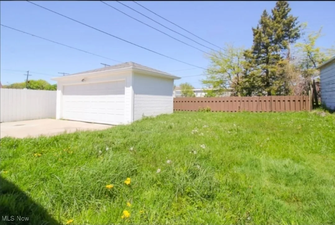 View of yard with a garage and an outbuilding