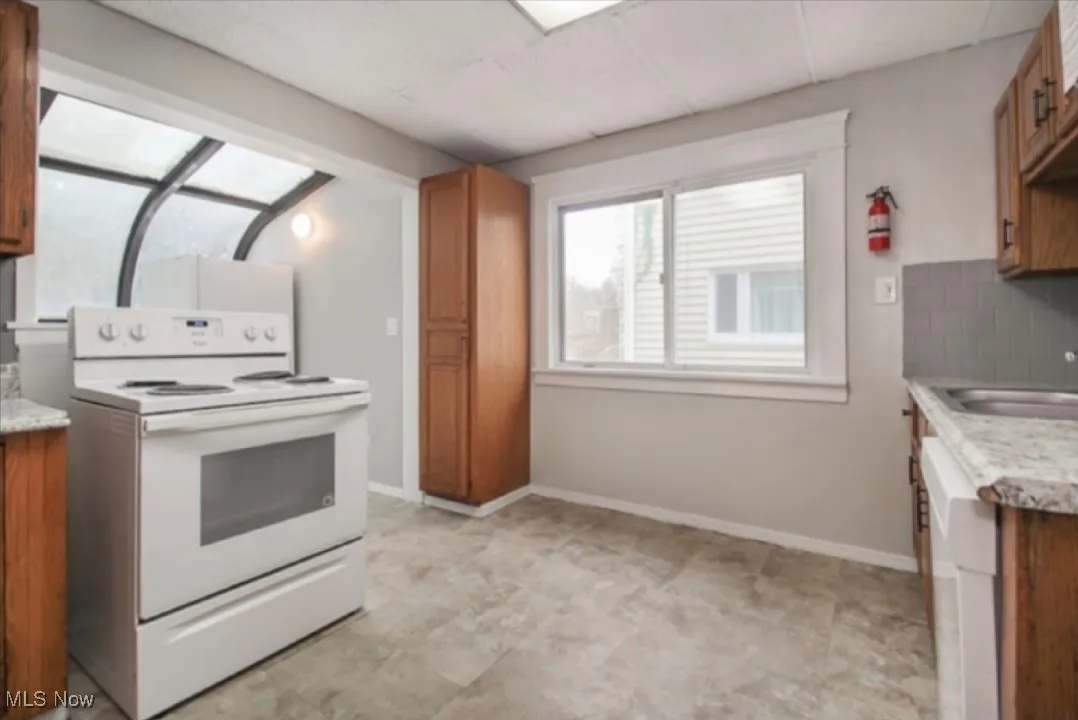 Kitchen featuring electric stove and brown cabinets
