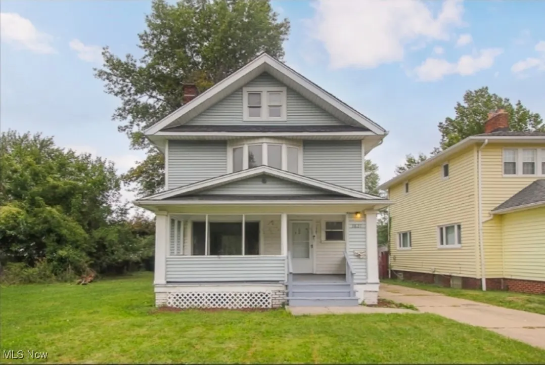 Traditional style home with covered porch, a front lawn, and a chimney