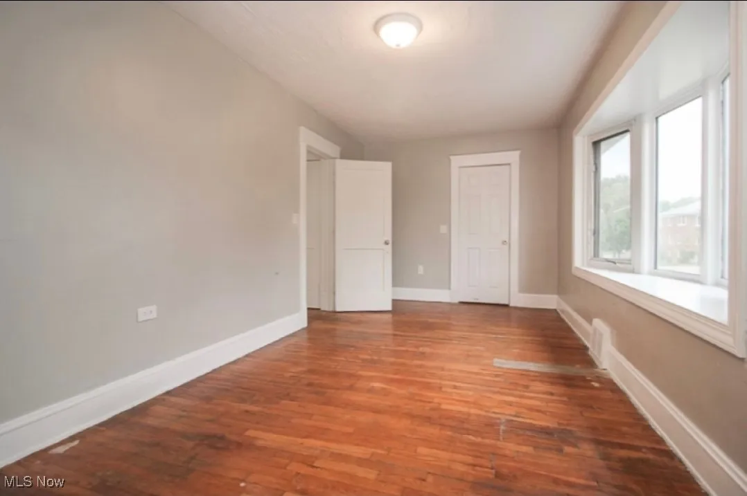 Empty room with hardwood / wood-style floors and baseboards