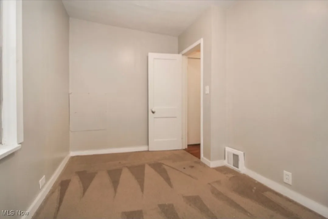 Carpeted empty room featuring baseboards